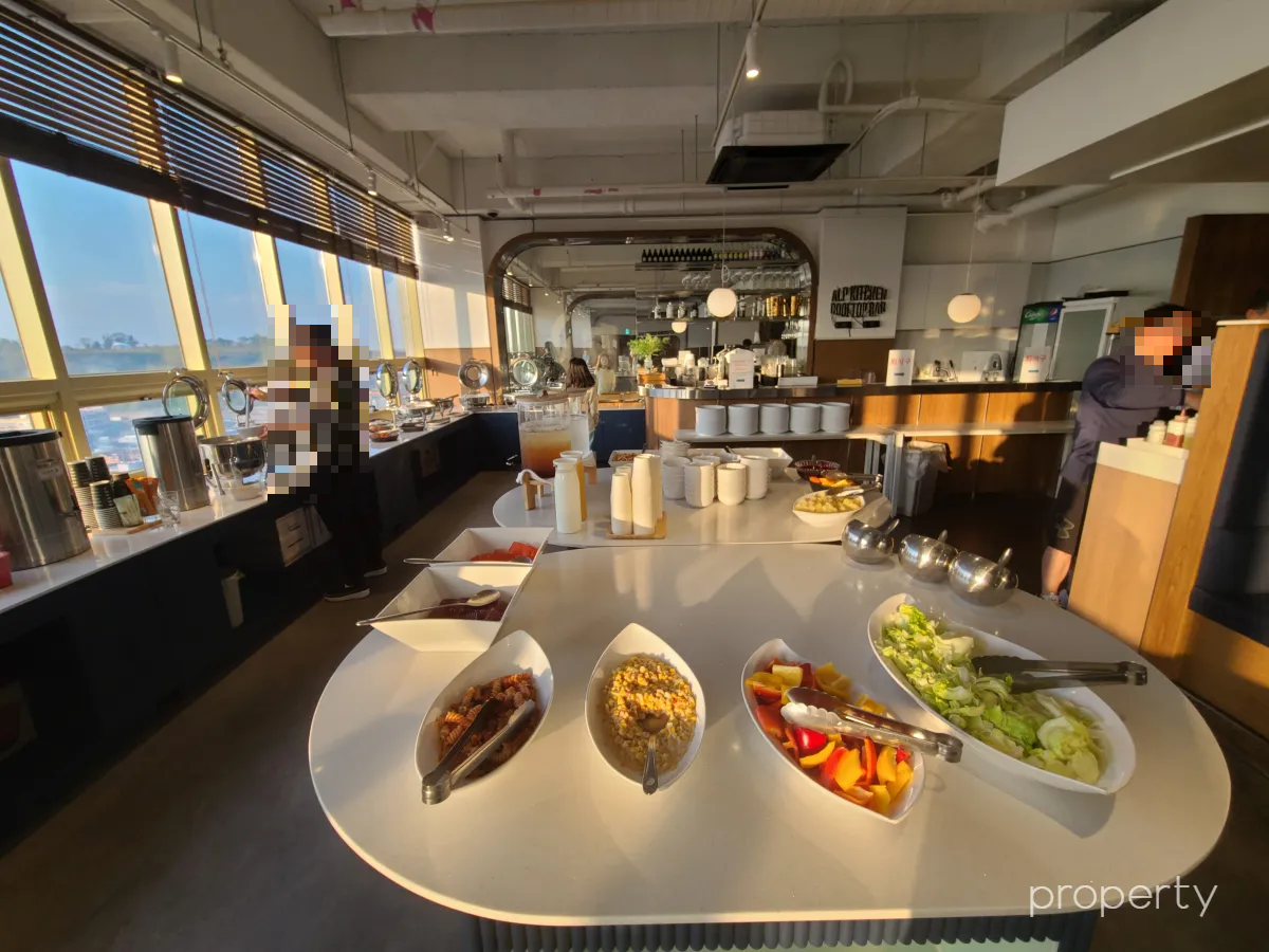 조식뷔페음식-흰색테이블위에샐러드-창가에진열된음식들-창밖에보이는파란하늘