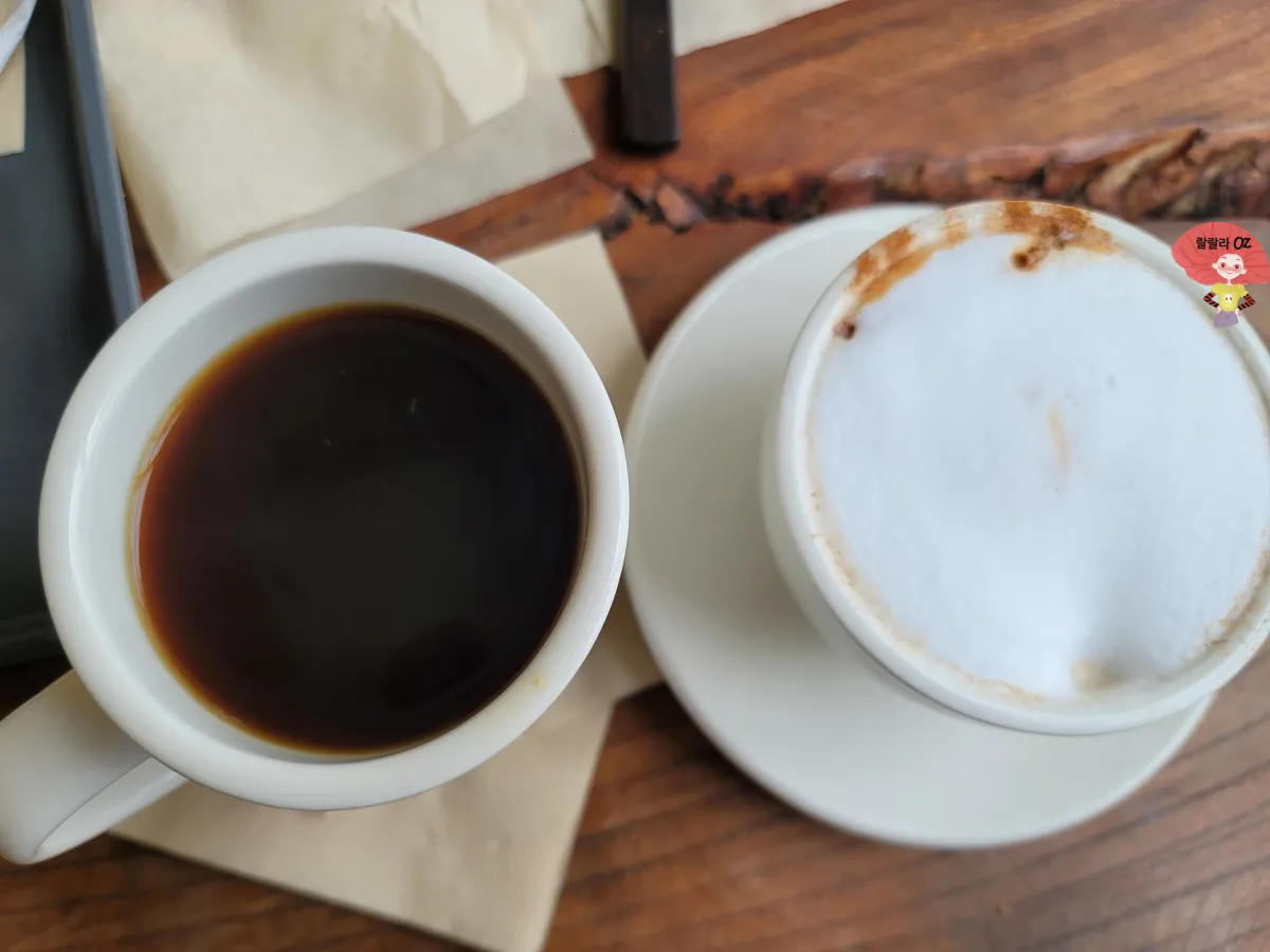 경기-양평-북한강뷰-쌀베이커리카페-그림정원-핫아메리카노와-바닐라-라떼가-담긴-찻잔