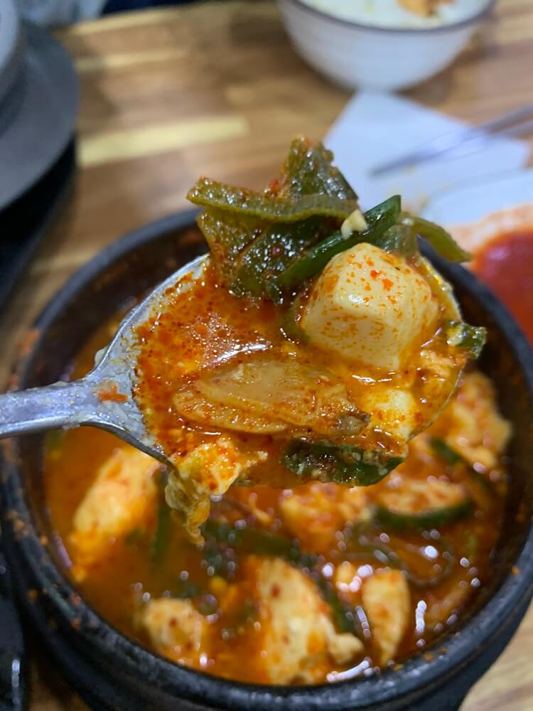 야채와 순두부가 가득 담겨있는 숟가락