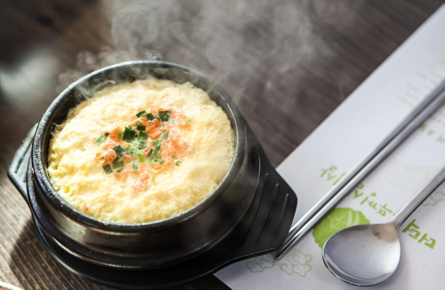 계란찜 맛있게 하는법 : 테이블 위에 계란찜과 젓가락, 숫가락이 놓여있다.