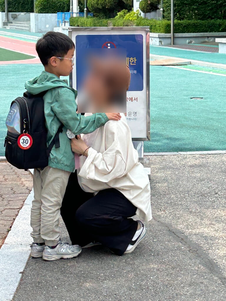 서있는 아이와 앉아있는 엄마