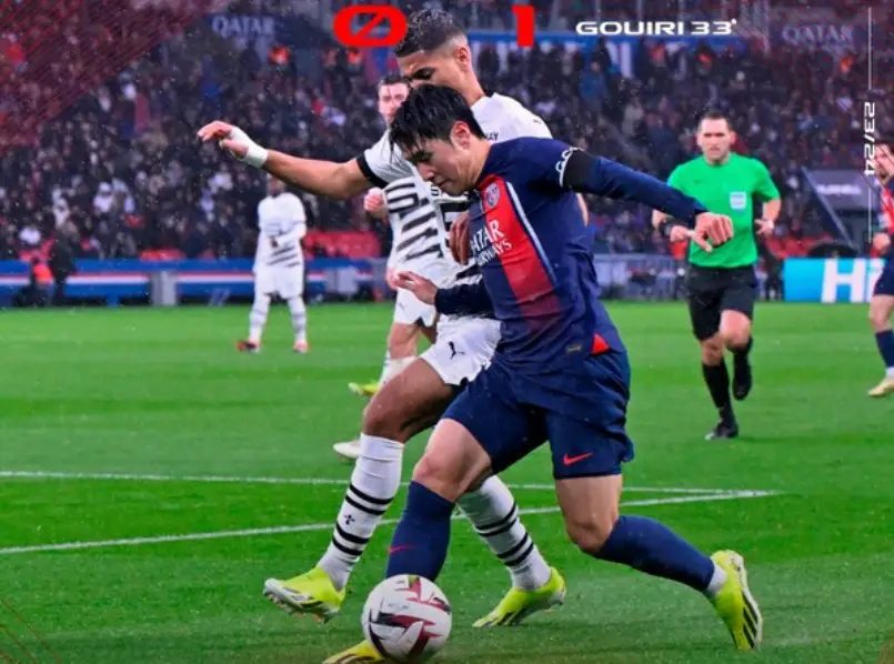 이강인- 붉은색과 파란색이 섞인 유니폼을 입고 흰색 유니폼을 입은 상대선수와 몸싸움을 하겨 공을 몰고있는 이강인