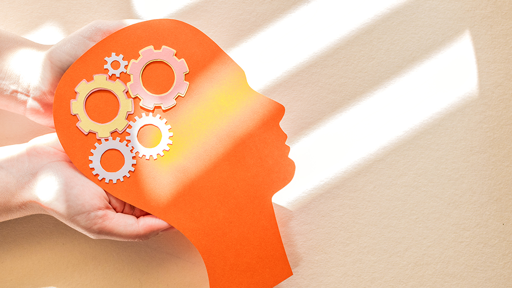 주황색 사람 머리 모양 안에 다섯 개의 톱니바퀴가 그려진 그림