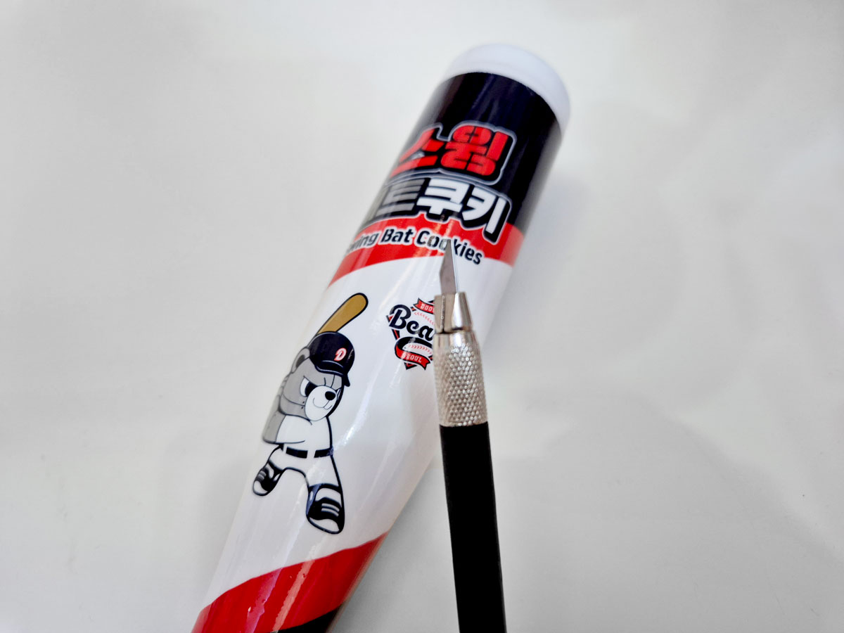 포장을 벗겨내기 위해 칼을 준비함