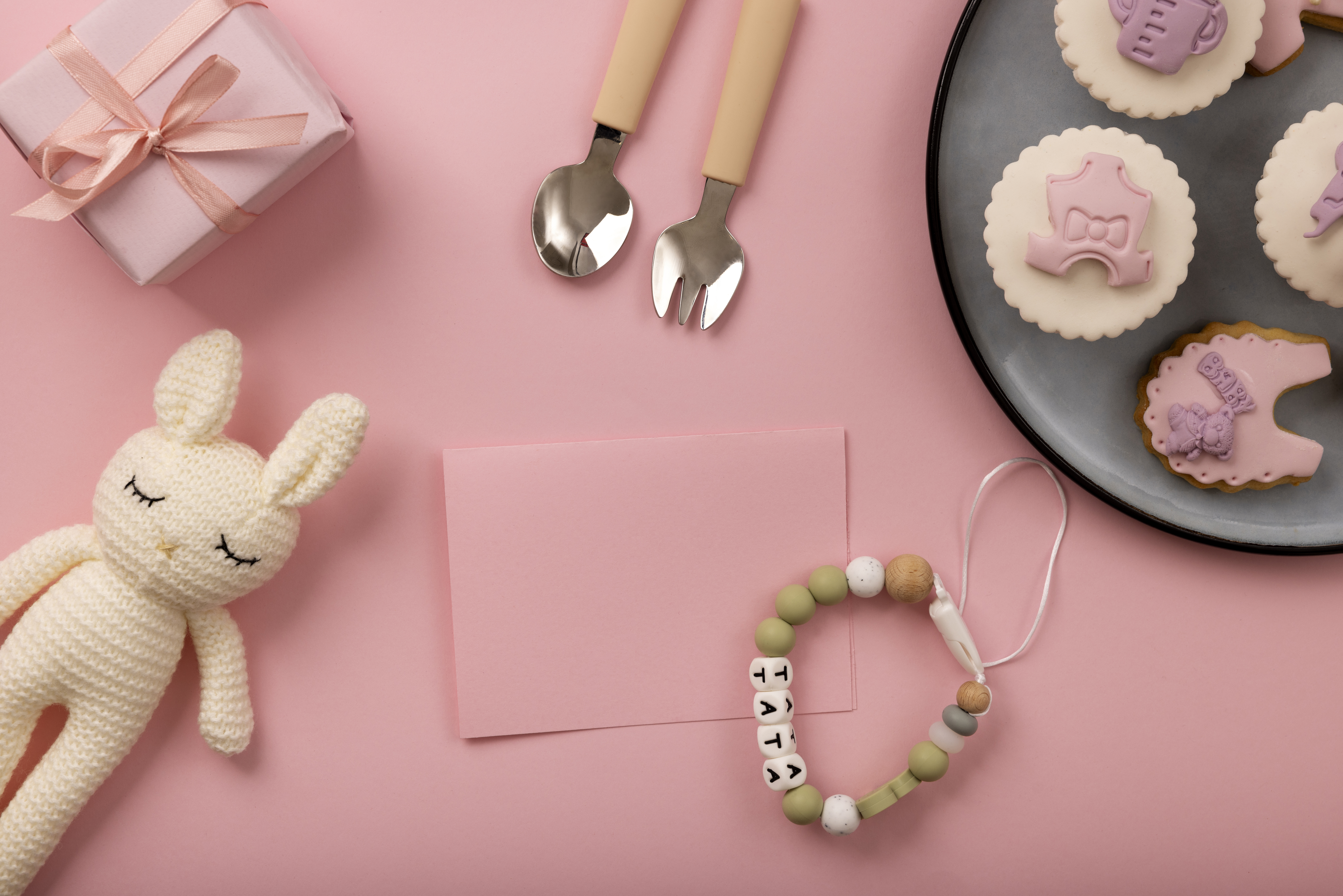분홍 배경 위에 놓인 아기용품 선물 세트 구성