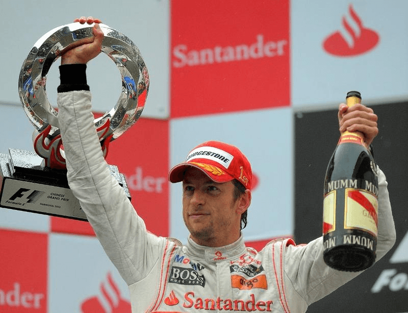 McLaren-Mercedes driver Jenson Button of Britain shows off his trophy while holding a bottle of champagne on the podium after winning Formula One's Chinese Grand Prix in Shanghai on April 18, 2010. (GOH CHAI HIN / AFP)