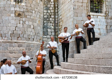 성벽에 남자들이 각 계단에 하나씩 올라 줄지어서 각자의 악기로 연주를 하는 사진입니다.