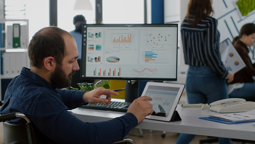 사무실에서 pc와 테블릿으로 업무를 하고 있는 남성의 사진입니다.