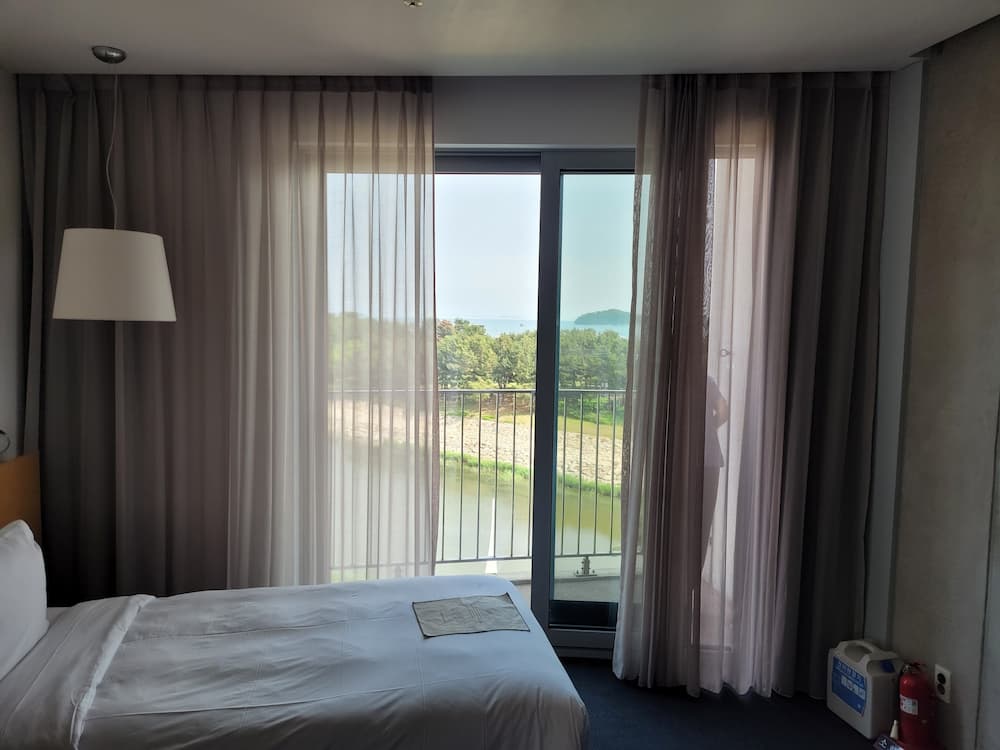 인천 영종도 네스트호텔의 빈 침대와 바다가 보이는 풍경