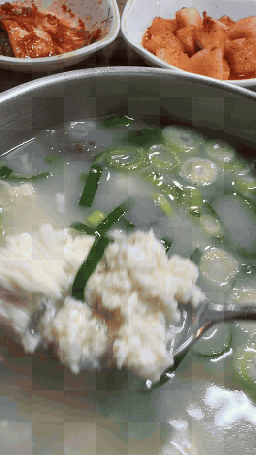 숟가락으로 떠올린 광덕식당 소순이의 순두부 모습. 뽀얀 소고기 국밥 국물에 부드러운 순두부가 가득 들어간 강릉 해장 음식 GIF 이미지.