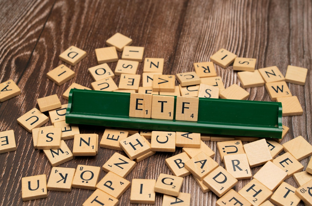 테이블 위에 알파벳이 적힌 나무조각들이 있고 ETF라고 써있다