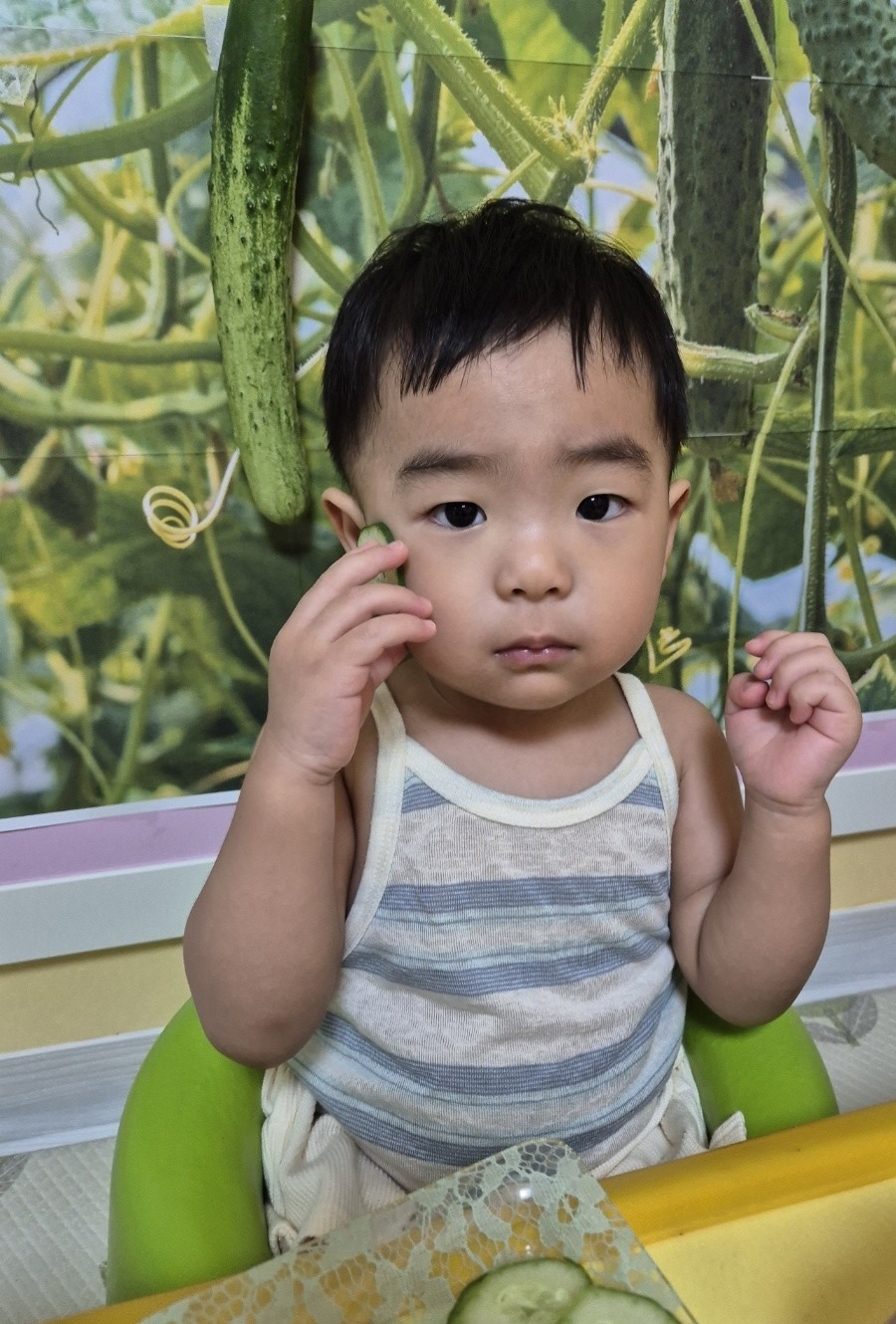 오이 조각으로 오이 마사지를 하는 아이