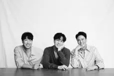 테이블 앞에 앉아 웃는 세사람