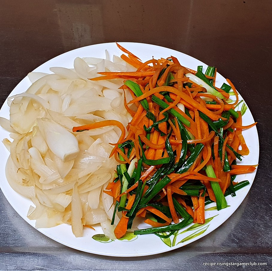 잡채에 들어갈 야채 고명(양파, 당근, 쪽파)을 전부 볶아서 접시에 담아 둔 사진