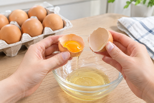 계란을 깨뜨려 내용물의 상태를 확인하는 모습