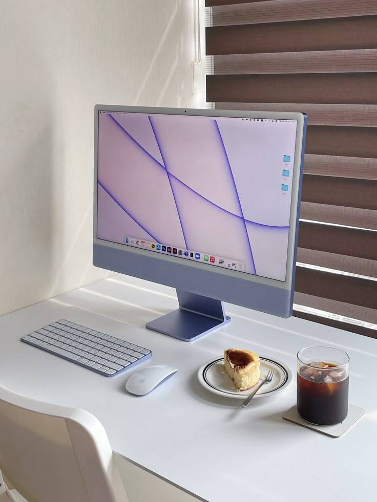 아이맥 24인치 퍼플 모델과 미니멀 데스크 셋업, 커피와 디저트가 함께 놓인 장면