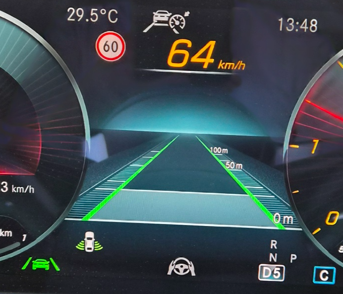 벤츠 계기판에 차선 유지 보조 경고가 표시된 화면. 주의 레벨 메시지와 함께 속도 및 경고 아이콘이 표시됨.