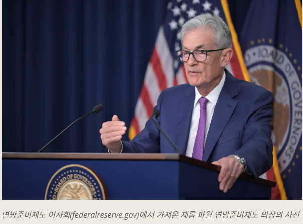제롬 파월 미국 연준 의장이 연단에서 마이크를 앞두고 금리 및 경제 전망 분석을 발표하는 사진