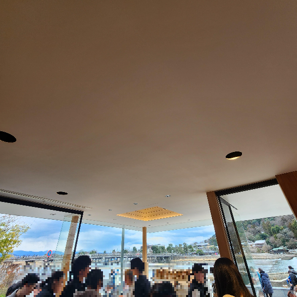 북적이는 카페 내부. 창이 넓어 강을 포함한 풍경이 카페 공간으로 보인다.