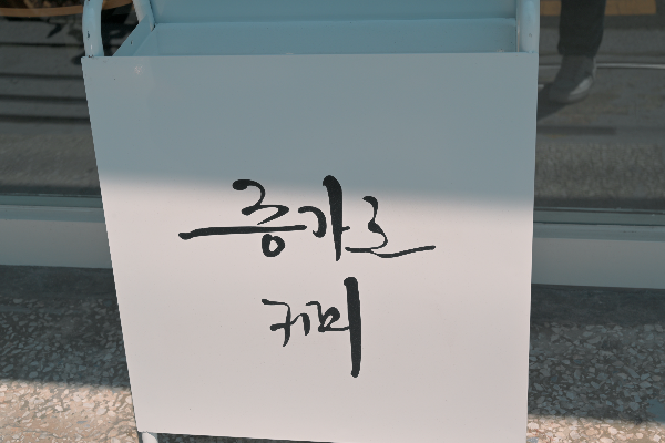 흰바탕에 흘림체로 '증가로 커피'라고 쓰여 있는 입간판