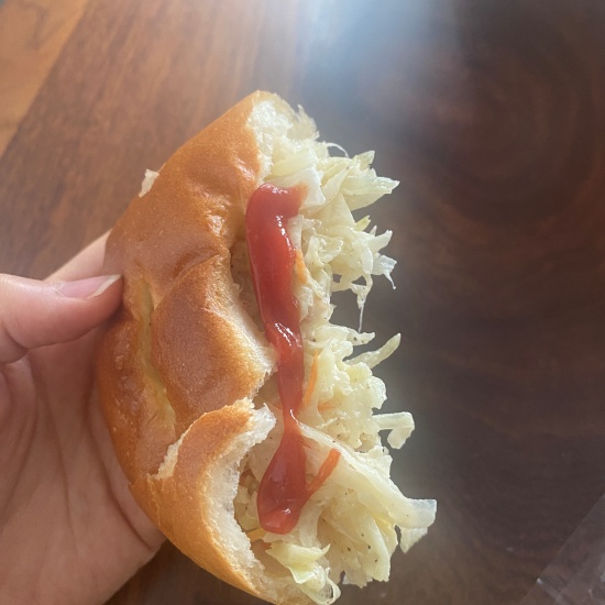 빵 안에 채 썬 야채가 가득하고 그 위에 케첩이 뿌려져 있습니다.