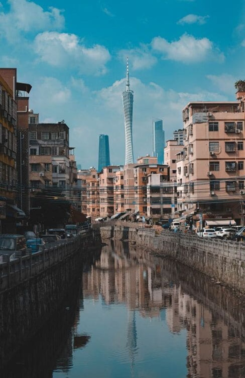 광저우의 옛 주거지와 현대적 광저우타워가 어우러진 풍경으로, 도시의 과거와 현재가 함께 보이는 장면