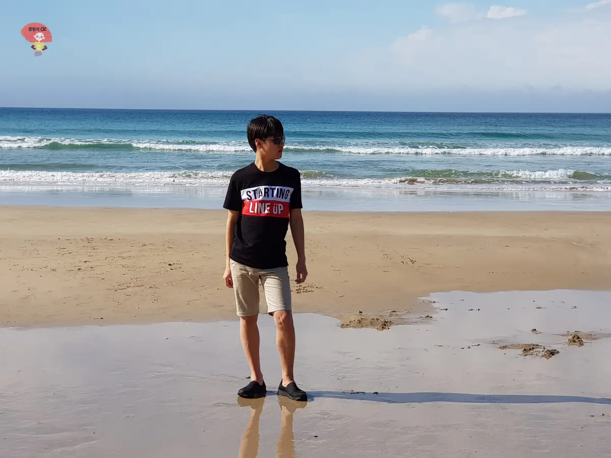 호주-멜버른-그레이트-오션-로드-해변에서-썬글라스를-착용하고-서-있는-소년