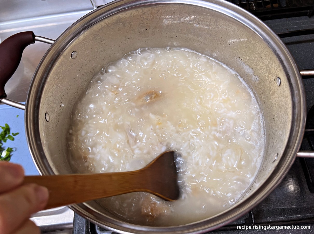 끓고 있는 치킨 닭죽을 주걱으로 저어주는 사진