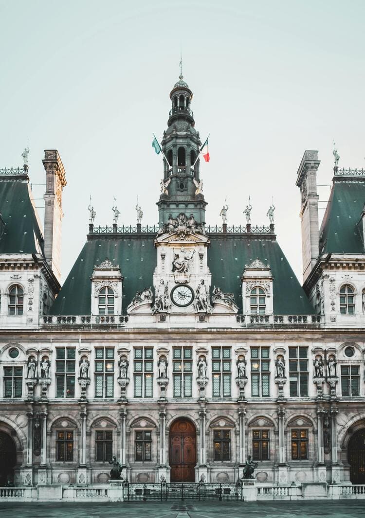 파리 시청 건물의 고전적인 외관과 조각상들이 어우러진 사진으로 프랑스 건축미를 보여주는 장면
