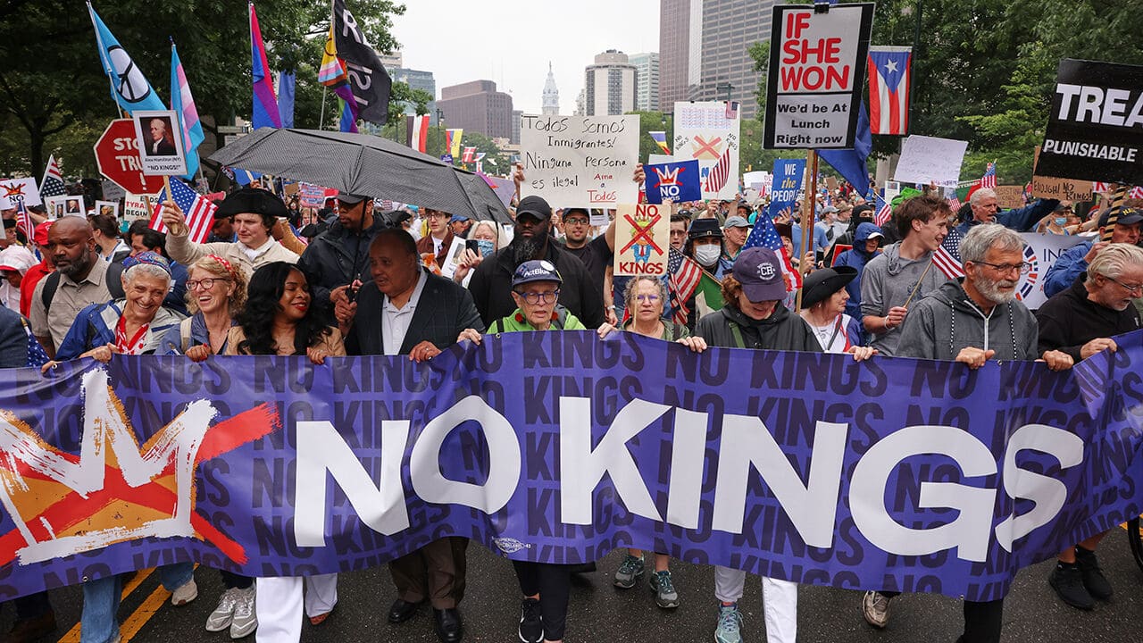 반트럼프 시위에서 NO KINGS 현수막을 들고 서있는 시위대