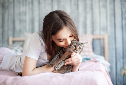 당뇨병이 있는 고양이를 안고 있는 여자.