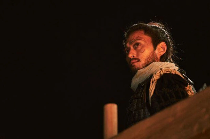 조선 수군 복장을 하고 배 갑판에 서 있는 준사 역의 배우 김성규