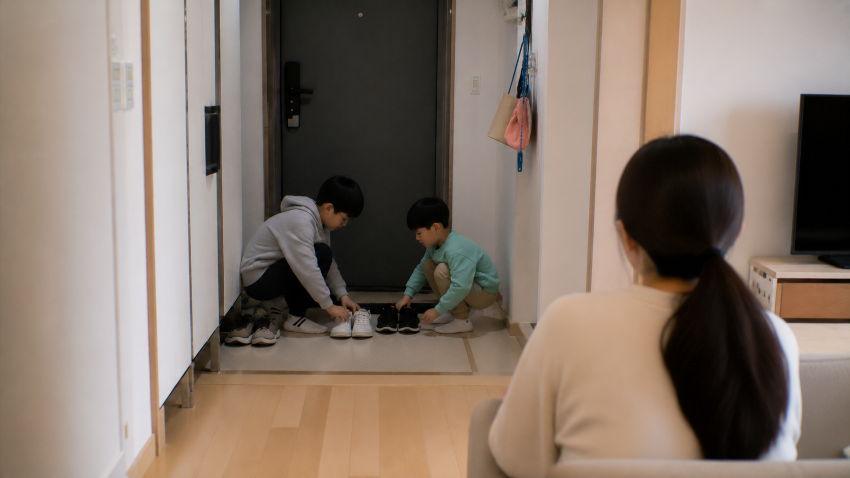 현관에서 신발을 정리하는 초등학생 형제