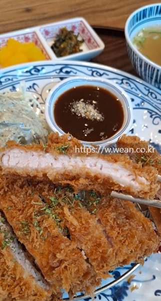 젓가락으로 돈가스 조각을 들었어요.