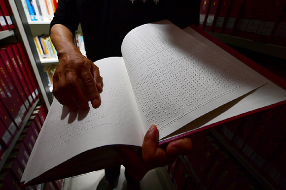 최영호 광주시립점자도서관장이 14일 오전 광주 남구 광주시립점자도서관에서 점자로 번역된 대체자료를 읽고 있다. 위 사진은 기사 내용과 무관함. [사진=뉴시스]