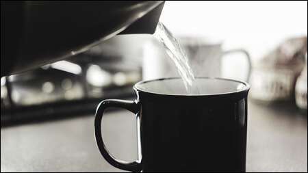 뜨거운 물을 컵에 담고 있는 모습