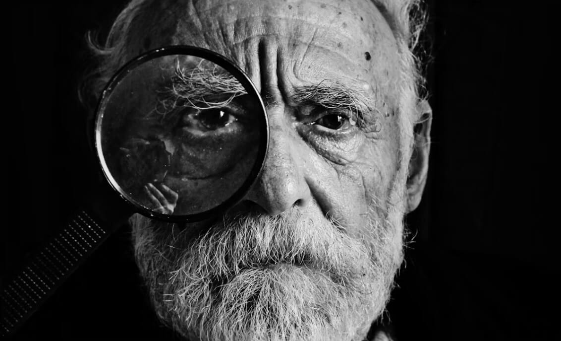 한쪽 눈에 돋보기를 대고 있는 노인