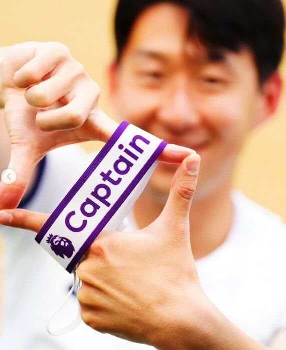 토트넘의 새로운 주장 손흥민이 웃으며 완장을 펼져보이는 모습