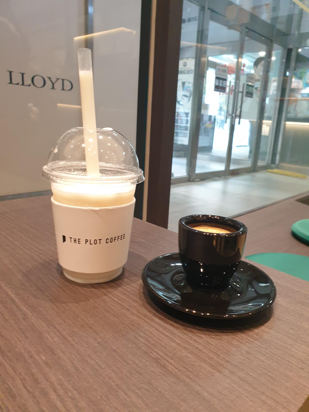 왼쪽에는 일회용 컵에 참외 슬러시가 오른쪽엔 검은색 에스프레소 잔에 에스프레소가 보인다.