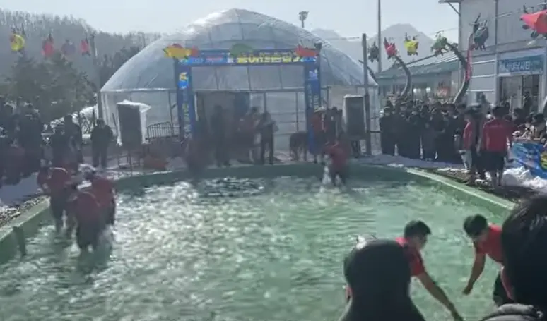 겨울방학 국내 여행지- 동그란 물이담긴 타원 안에서 사름들 8명이 물고기를 잡고있는 모습