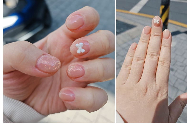 은은한 반짝이와 귀여운 리본 파츠가 어우러진 누드톤 봄 네일아트 완성