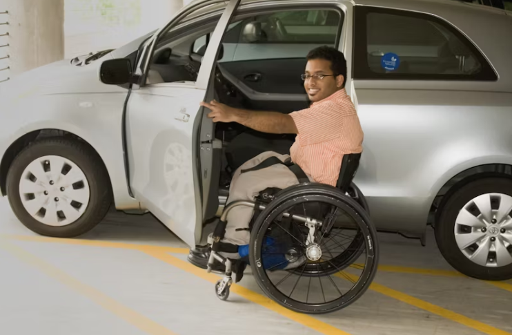 휠체어를 사용하는 남성이 차량에 탑승하려고 하는 모습. 장애인 차량 이용과 이동권을 상징적으로 보여주는 이미지