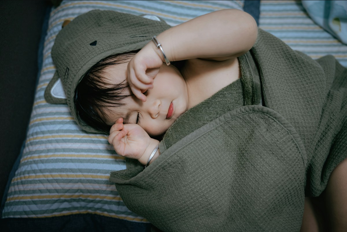 Baby sleeping peacefully wrapped in a hooded towel