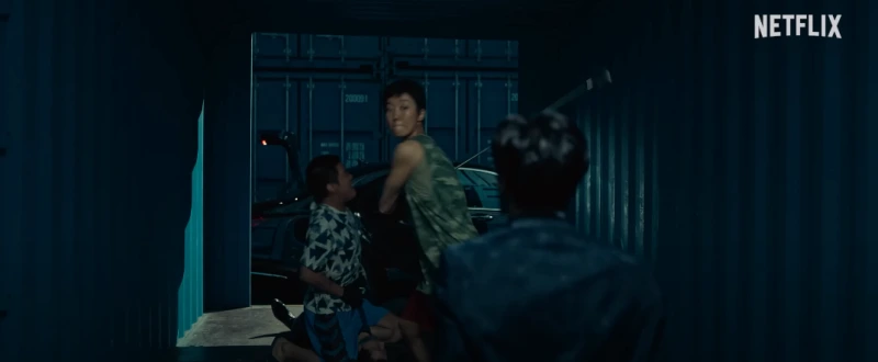 컨테인 박스에 골프채를 휘드르고 있는 독전 2의 만코, 로나