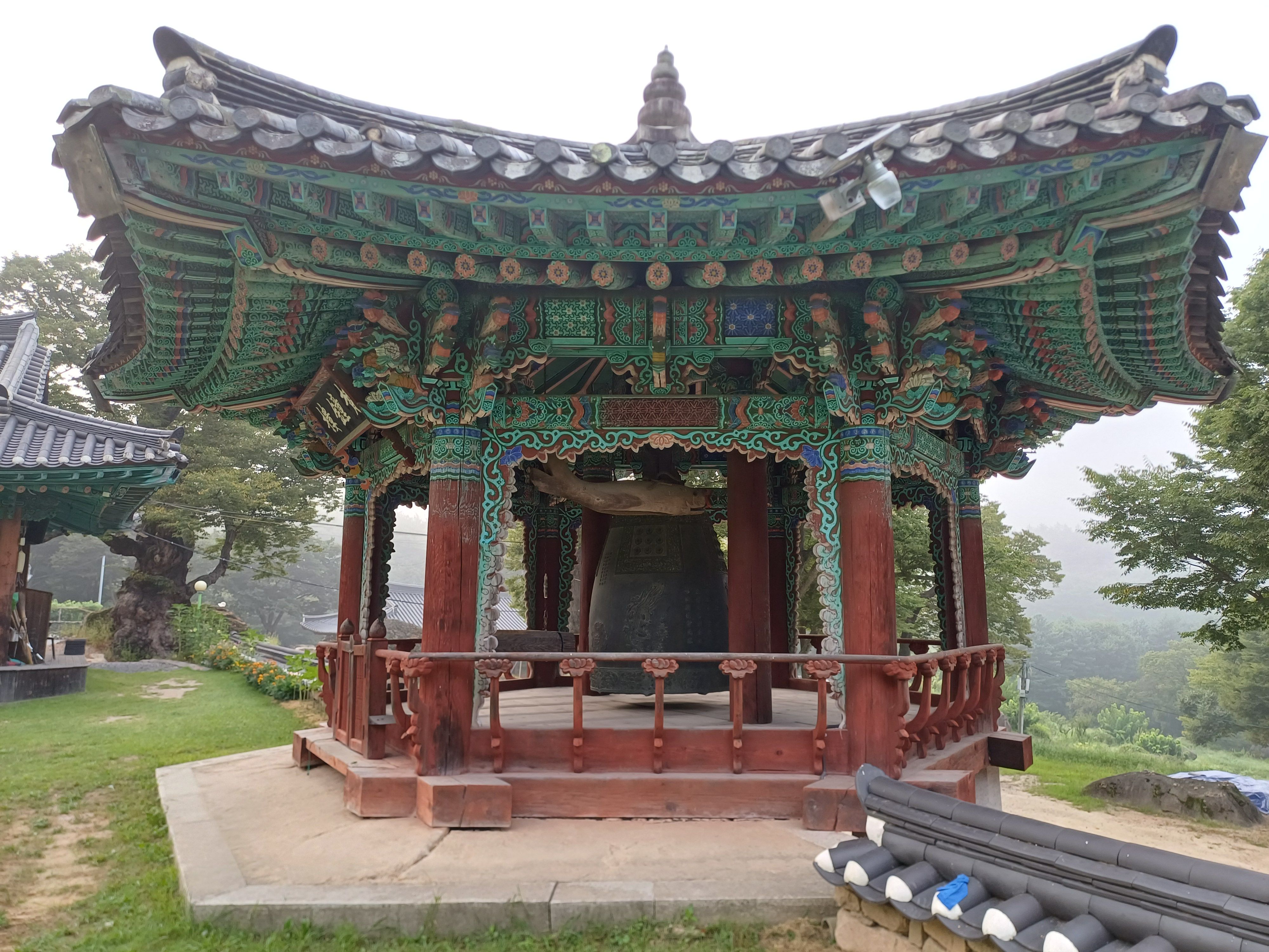 종각 내부의 범종과 단청 천장 디테일, 측면 구도