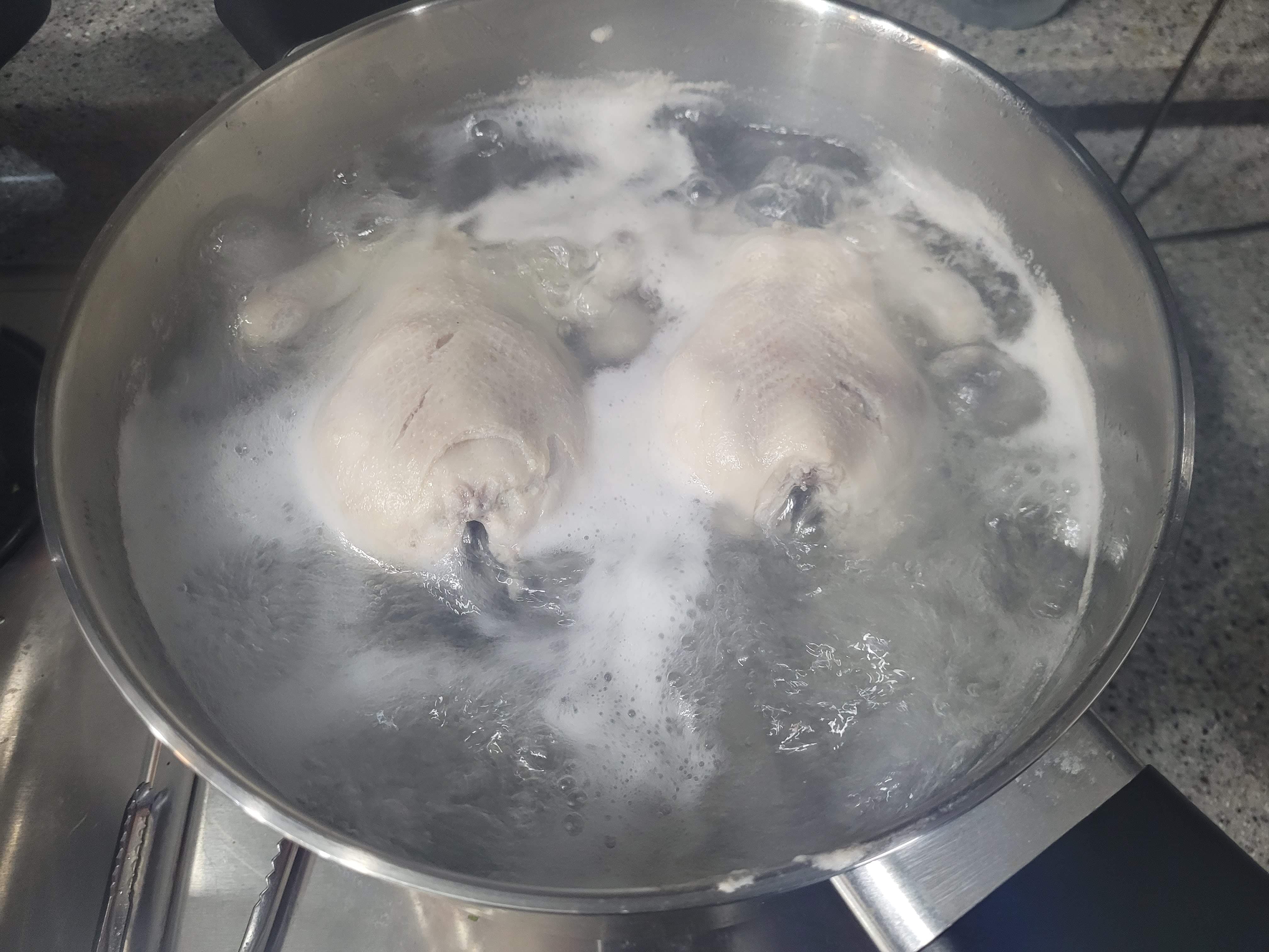 냄비에서 끓고 있는 닭 두마리
