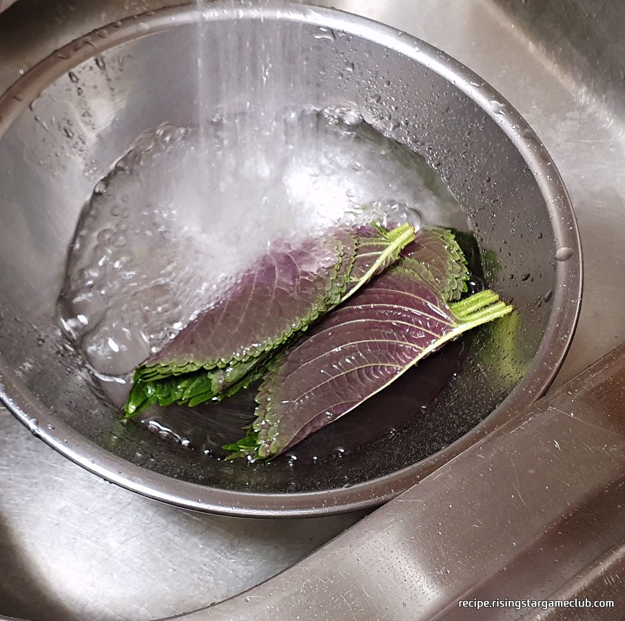 깻잎전에 들어갈 깻잎을 흐르는 물에 담그는 사진