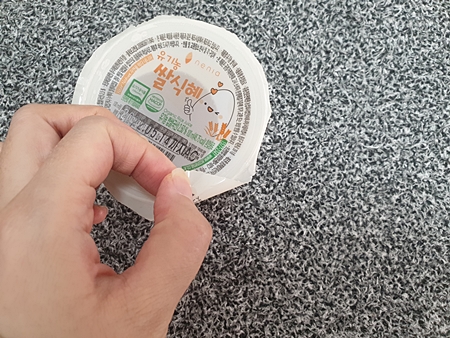 뚜껑을 손으로 잡은 모습