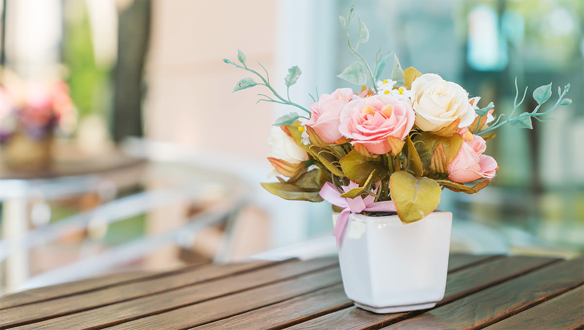 테이블 위에 예쁜 꽃화분이 있는 모습