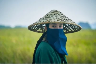 푸른 보리밭을 배경으로 삿갓을 쓰고 얼굴은 두건으로 가린채 긴 댕기머리를 하고 있는 드라마 연인의 청나라 포로 사냥꾼 여자 캐릭터